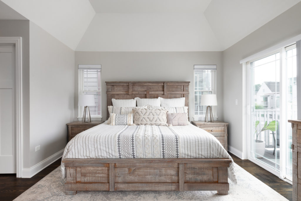 A bedroom with a wood headboard and footboard.